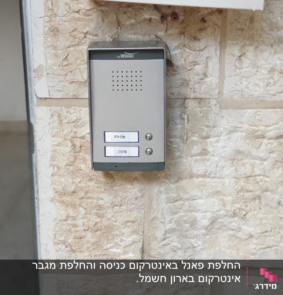 אינטרקום עם שני כפתורים ושמות על קיר אבן